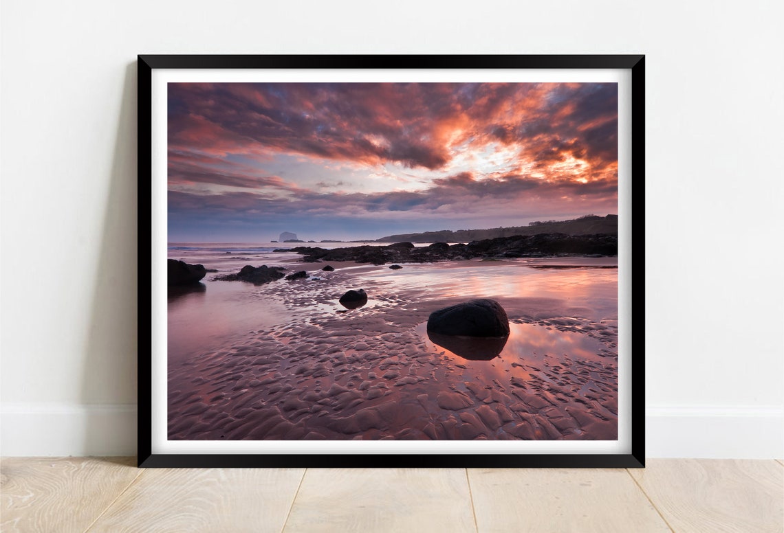 Crimson Sunset Over Wet Sand and Rocks with Reflections Poster